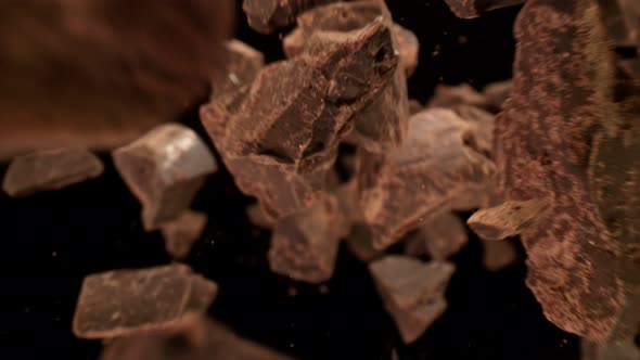Super Slow Motion Detail Shot of Raw Chocolate Chunks Flying Towards Camera at 1000Fps alt