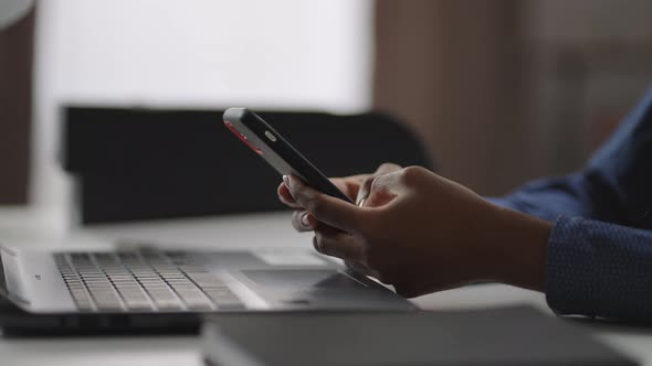 Black Woman is Using Smartphone in Office Closeup of Hands with Gadget Viewing News Tape in Social alt