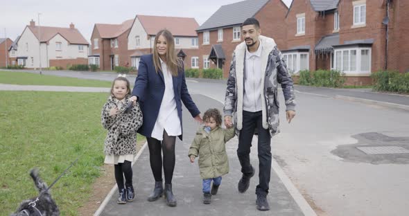 Happy multiracial family having a walk together on the pavement