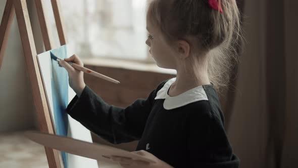 Little Girl Draw A Picture On Easel