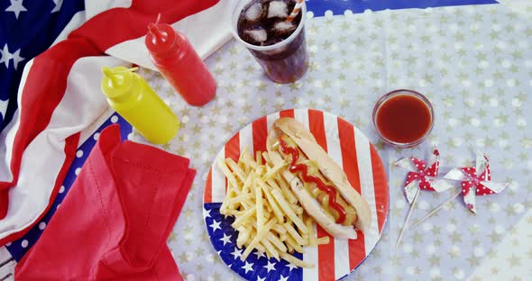 Hot dog, french fries and cold drink served on a table with 4th july theme alt
