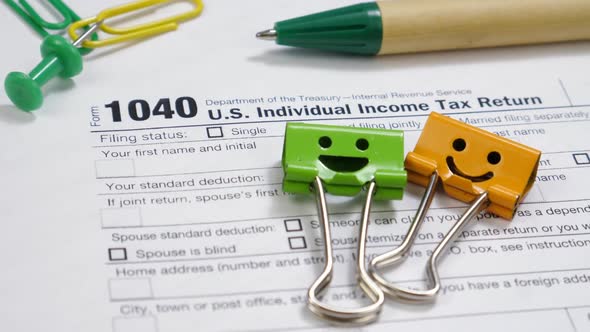 Smiles Binder Clips and Pen on 1040 Tax Form
