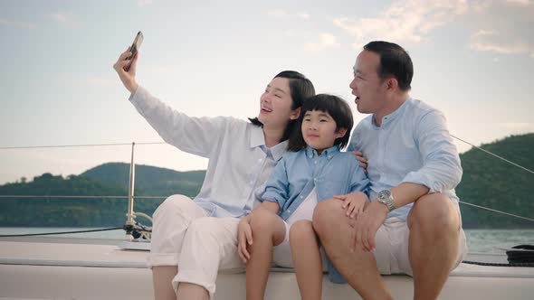 Asian father teaching son to steer a yacht, holiday activities,travel,leisure