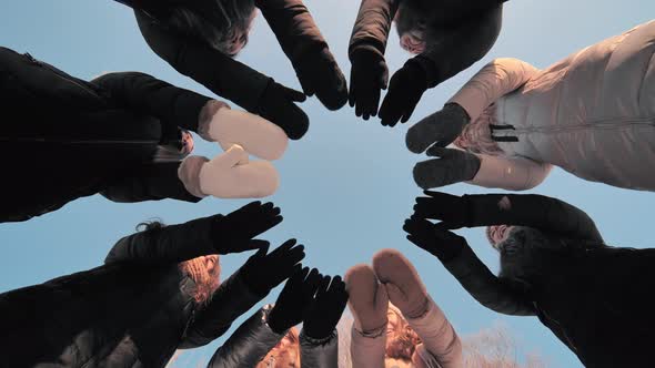 Friends on a Winter Day Join Their Hands with Mittens in a Circle alt