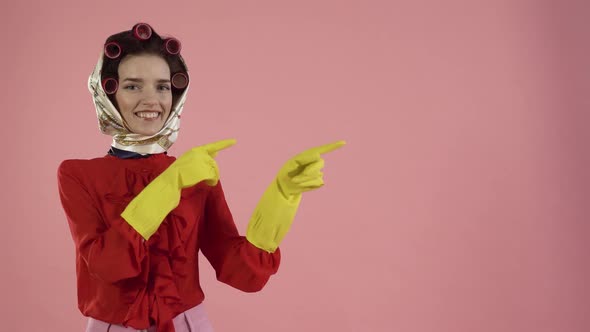 A Young Female Cleaning Lady Points Her Hands at a Copy of the Spaces and Smiles