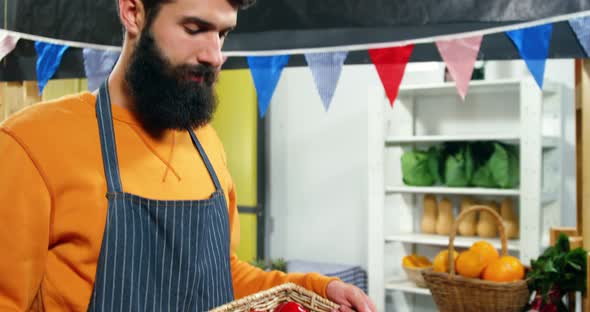 Portrait of male staff holding fresh vegetables in crate alt