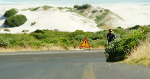 Triathlete man cycling in the countryside road alt