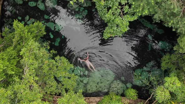 Young Brunette Woman Swim in a Natural Pool of a Cenote in Mexico