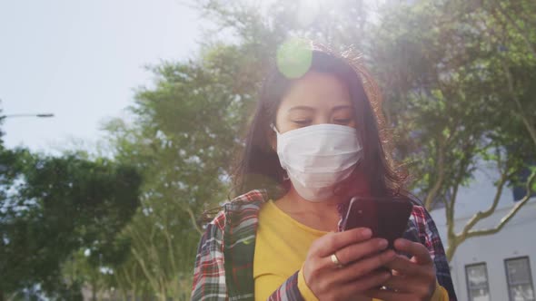 Mixed race woman wearing medical coronavirus mask on the street alt