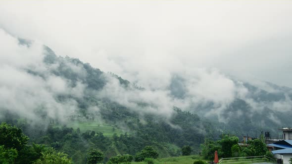 A Foggy Mountain Landscape in Nepal with the Glimpse of its Suburban Life alt