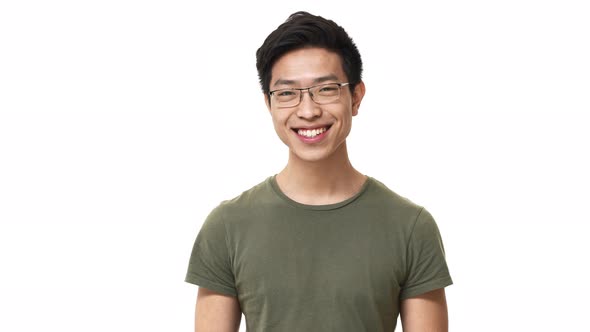 Portrait of Smiling Asian Man Wearing Eyeglasses and Basic Tshirt Nodding in Acceptance Meaning Yes alt