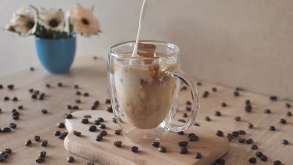 Milk Cream is Poured Into a Iced Coffee alt