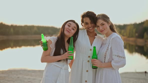 Group of Female Friends Laughing and Looking at the Camera at the Beach Party alt