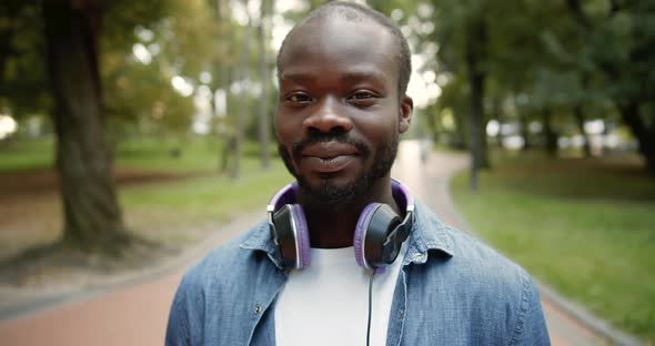 Portrait of Afro-American in Headphones Outdoors