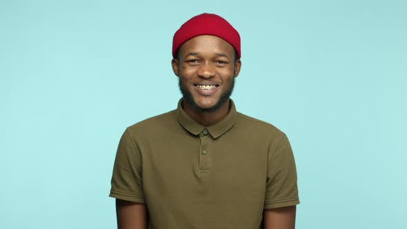 Slow Motion of Handsome African American Man in Red Beanie Starts to Laugh and Smiling Happy Showing