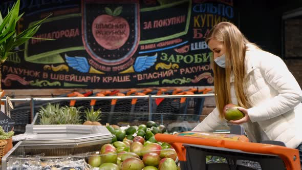 Young Woman Buys Mangoes at the Fruit Market alt