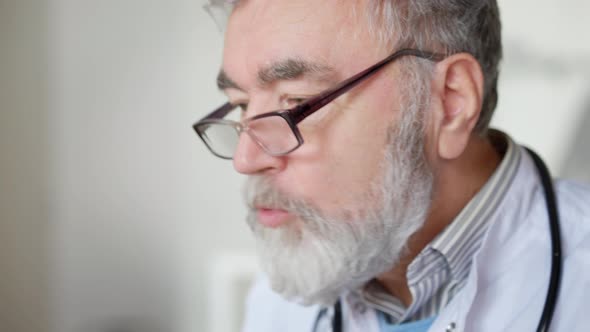 Headshot Portrait of Confident Doctor in Eyeglasses Talking and Showing Medications alt