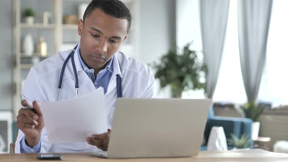 African-American Doctor Reading medical Report, Diagnosing Patient alt