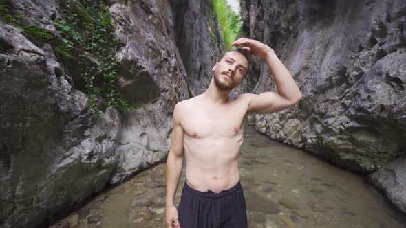 Sporty young man doing neck exercise in nature. alt