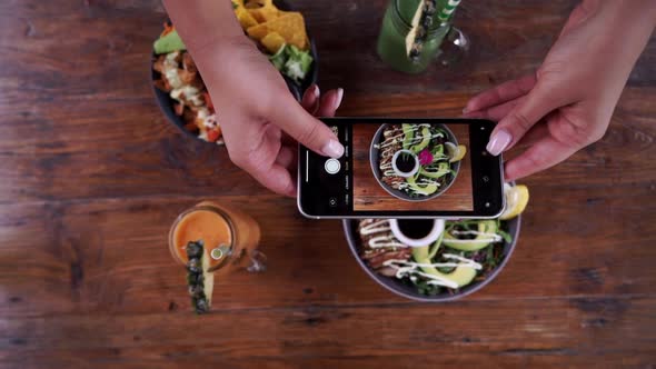 Female Hands Photographing Appetizing Food By Smartphone in the Restaurant. Blogger