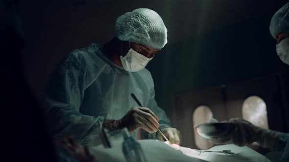 African American Surgeon Operating Patient in Sterile Hospital Emergency Room alt