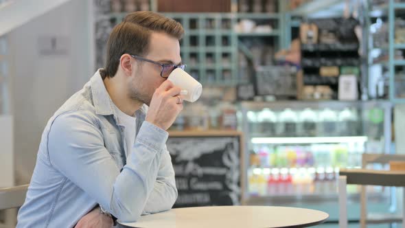 Relaxed Man Drinking Coffee in Cafe alt