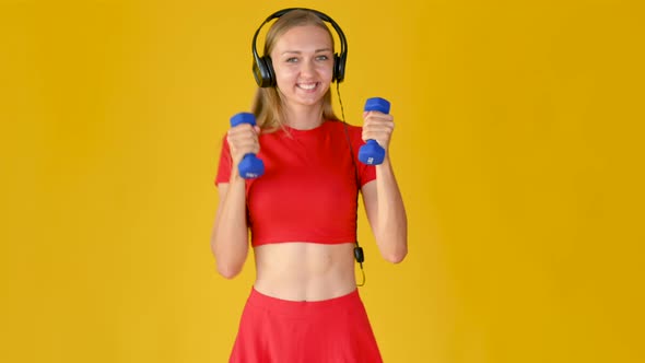 Young Girl in Sportswear with Headphones Exercising with Dumbbells