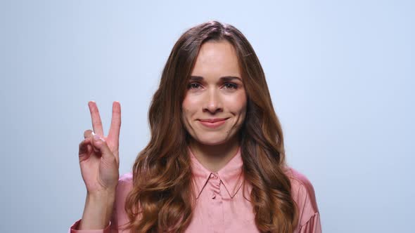 Businesswoman Showing v Sign in Studio. Woman Showing Peace Sign alt