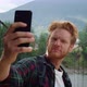 Confident Hipster Photographing Selfie Photo on Mobile Phone Outside Close Up - VideoHive Item for Sale