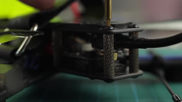 Extreme Close Up of Young Man's Hands Assembling FPV Racing Drone Using Screwdriver.