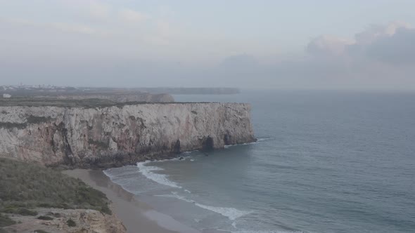 Breathtaking Aerial Drone View of Lagos Algarve Rocky Cliff Coastline Waves Crashing Against Shore alt