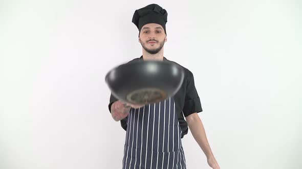 Chef Tossing Vegetables In Air in Slow Motion Against White Background alt
