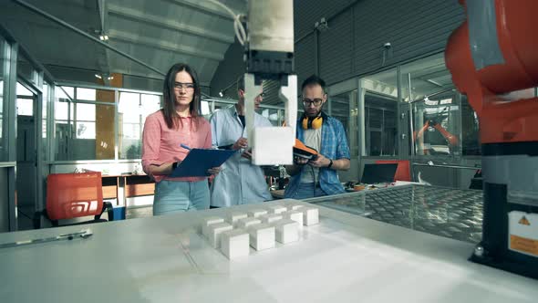 Team of Researchers Are Watching a Robot Relocating Things. Young Electronics Engineers Studing alt
