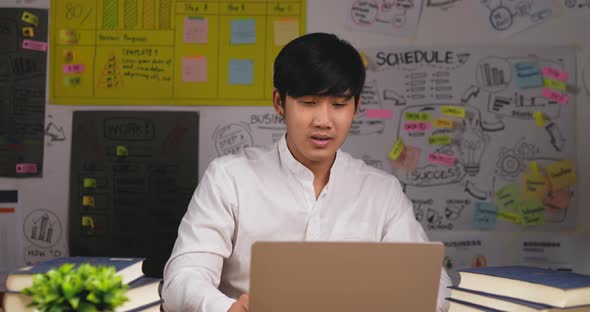 Successful business man sits at workplace desk with a laptop working alt