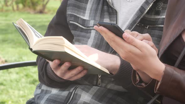 Beautiful Couple Sitting On A Bench In The Park In The Spring And Reading A Book alt