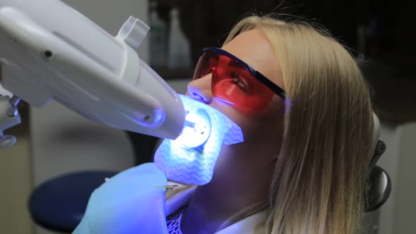 Dentist treating teeth to woman patient in clinic. alt
