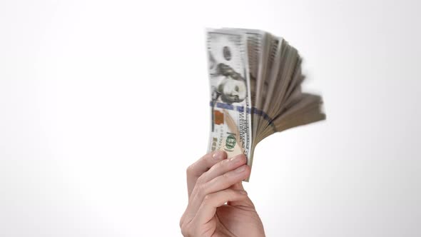 Hand on a White Background of Isolate Holds One Hundred Dollar Bills and Moves a Stack of American alt