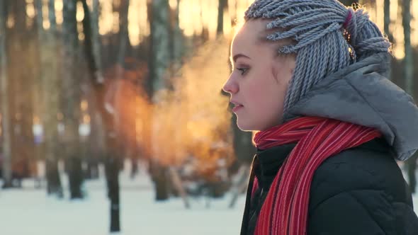 Woman Exhales Steam From Her Mouth in the Winter at Sunset