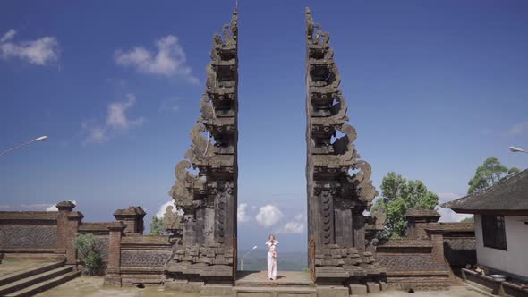Woman in White Dress Praying Standing in Famous Bali Gates Historical Sacred Sightseeing in alt