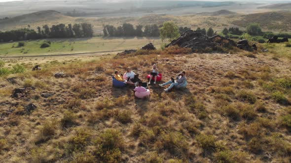 Team of Freelancers Work in the Fresh Air Sitting Comfortably in Bag Chairs and Listening to Lecture alt