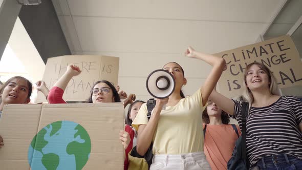 Multiethnic Group of Teenagers at a Protest March Carrying Signs with Environmental and Conservation alt
