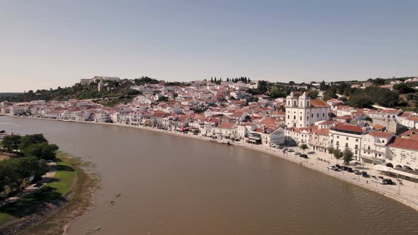Alcacer do Sal bridge against riverside cityscape, Portugal, Fly over Sado river. alt
