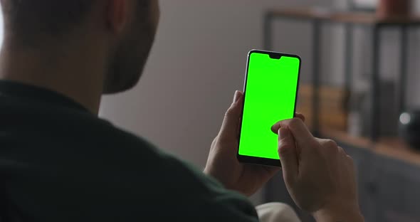 Man Is Browsing Internet Site Swiping Pages Holding Smartphone Vertically Green Screen Technology alt