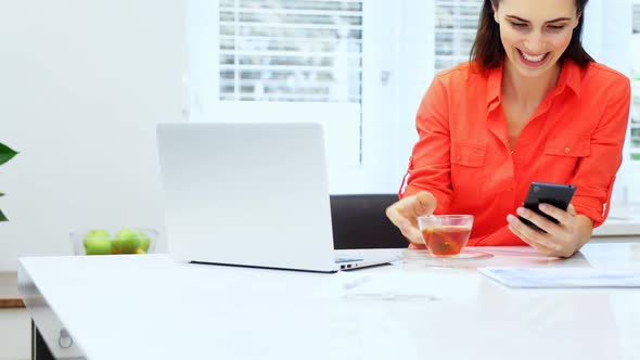 Woman using mobile phone at home 4k alt