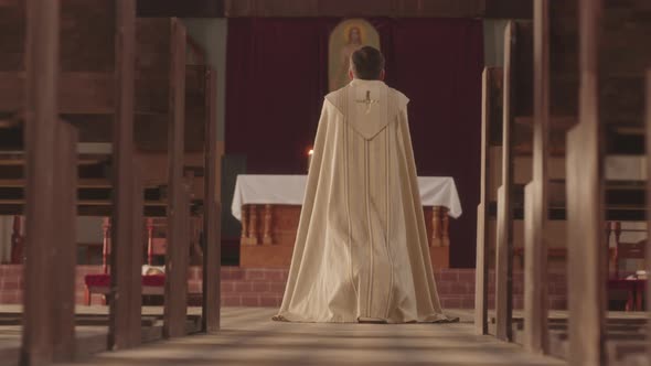 Priest Praying at Icon of Jesus Christ in Catholic Church alt