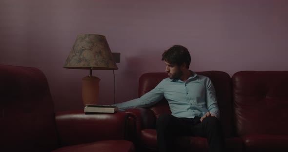 Boy turns on the lamp at home and reads a book alt