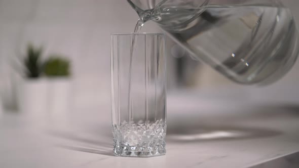 Pouring Clean Water From a Carafe Into a Glass