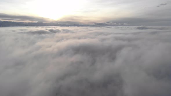 Incredible Aerial View Shot Above Swirling Fog and Clouds at Sunset in the Mountains alt