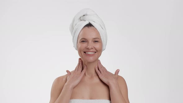 Beautiful Happy Middle Aged Woman Pampering Her Body After Shower with Pampering Lotion Posing with alt
