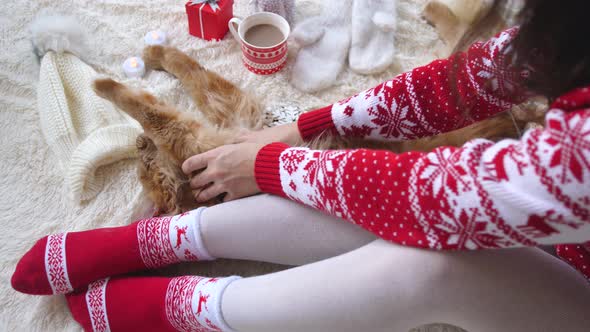 Girl Relaxing and Playing with Cat on Fluffy Floor Between Christmas Decorations